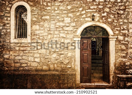 The door and window of an antique stone church on a grungy background