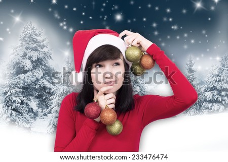 Young woman in Santa Claus clothes with christmas bubbles on a winter background