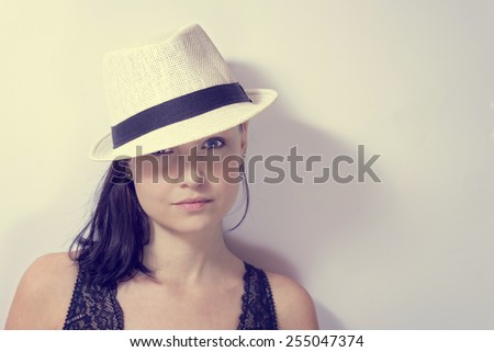 Portrait of a young woman with hat on an aged photo