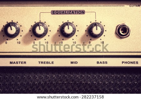Retro electric guitar amplifier close-up with knobs