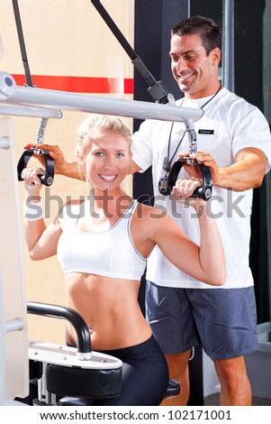 personal trainer helping client in gym