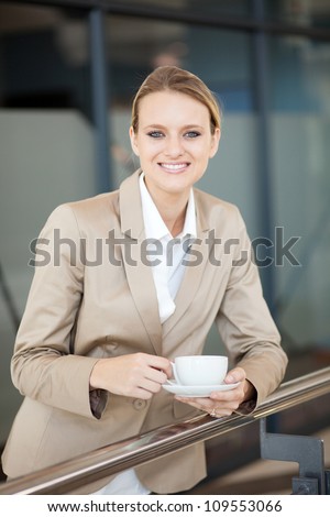 beautiful female white collar worker having coffee break at work