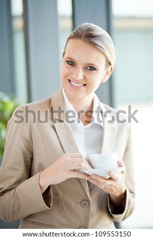 pretty young businesswoman having coffee break at work