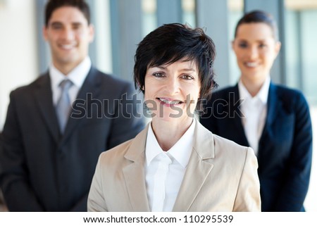 elegant middle aged businesswoman leader and team