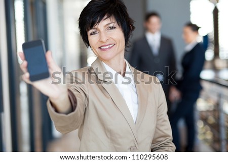 happy middle aged businesswoman showing smart phone