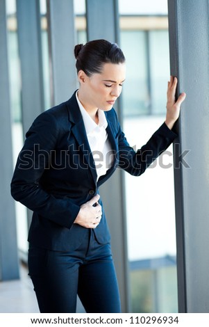 young businesswoman having period pain in office