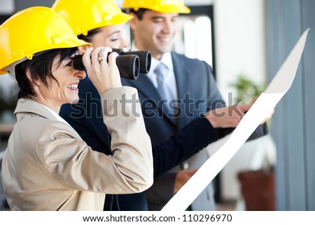 project manager looking at construction site with binoculars