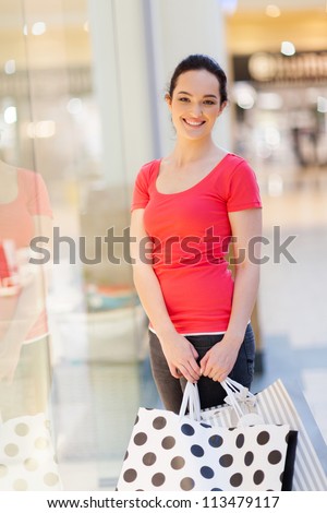 happy woman with shopping bags in mall