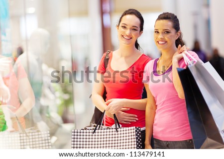 two happy friends shopping in mall