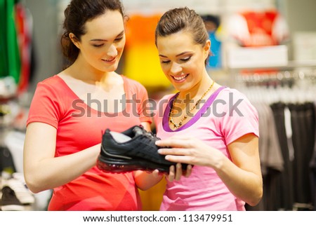 shop assistant helping customer choosing sports shoes