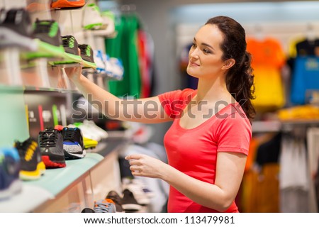 young female sportswear shop assistant working in store