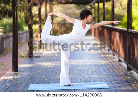 middle aged woman yoga pose outdoors