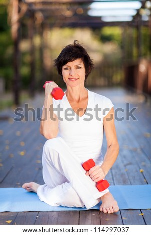 active middle aged woman exercise with dumbbells