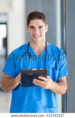 male medical doctor using tablet computer in hospital