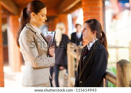 high school teacher talking to female student outside of classroom