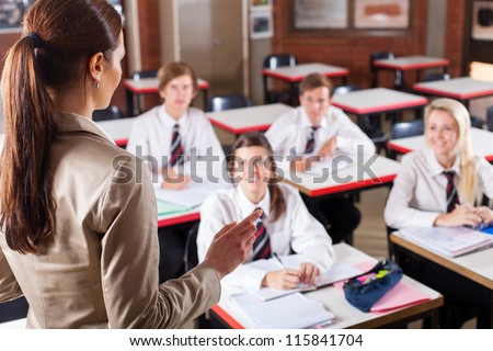 female high school teacher teaching in classroom