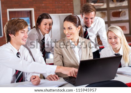 high school teacher and students with laptop in classroom