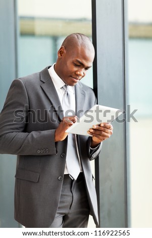 thoughtful african american businessman with tablet computer in office