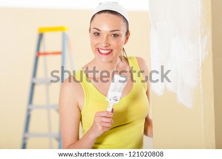 happy young woman painting new house
