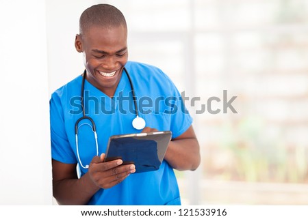 young handsome african american medical worker using tablet computer in hospital