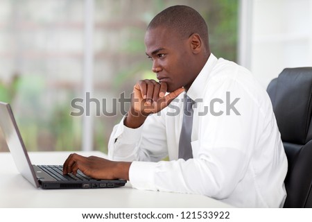 Thoughtful Young African American Businessman Working On Laptop Computer