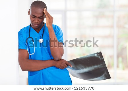 tired african american health care worker taking a break in hospital