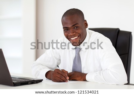 happy african american businessman writing report
