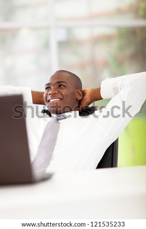 african american businessman daydreaming in office