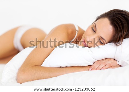 peaceful young woman sleeping on bed