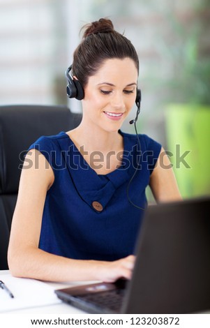 beautiful young online support operator working on laptop