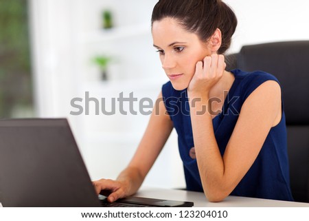 attractive young woman looking at laptop screen