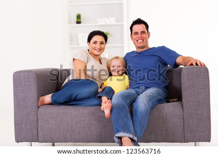 young happy family sitting on sofa at home