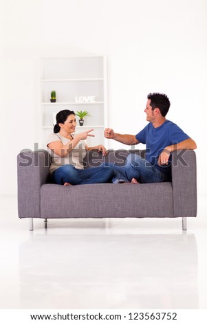 young couple playing rock-paper-scissors game at home
