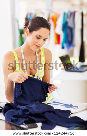 pretty fashion designer choosing fabric for her new design