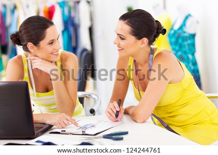 two happy fashion designers discussing new design in studio