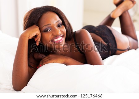 cute african american woman lying on bed