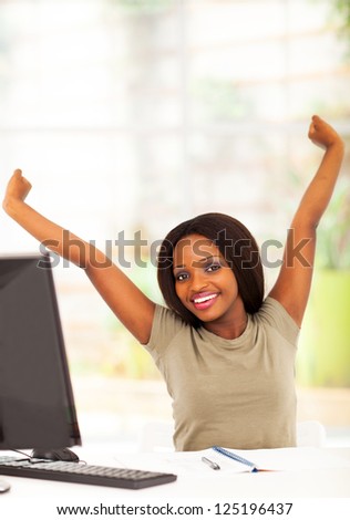 young african university student stretching before computer