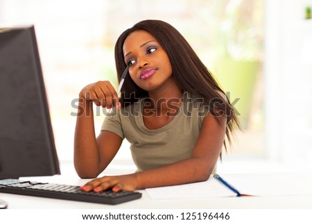 thoughtful african american female college student in front of computer