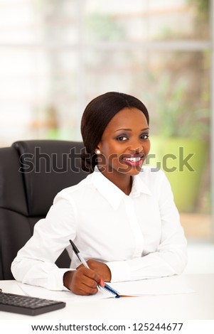 pretty young african american office worker by her desk