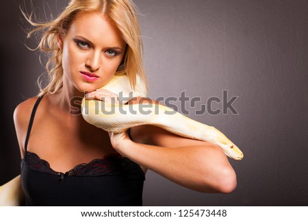 cool fashion woman holding python on her shoulder