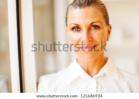 elegant middle aged businesswoman closeup portrait in office