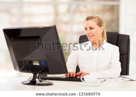 middle aged female office worker working on computer