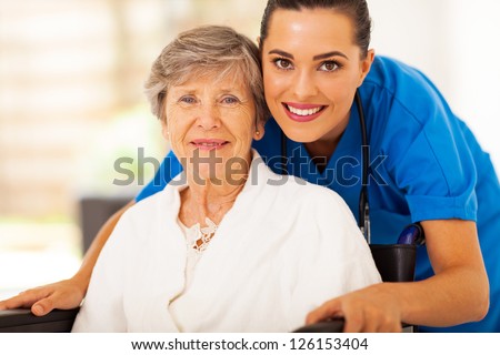 Happy Senior Woman On Wheelchair With Caregiver