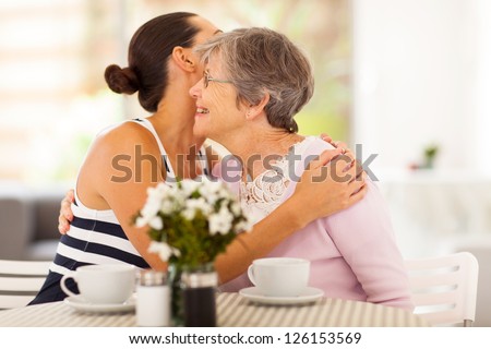 young woman hugging senior mother when visiting her