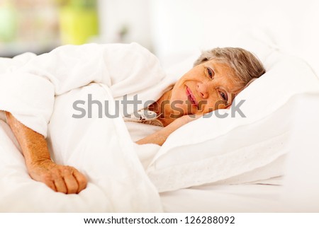 happy senior woman sleeping on bed