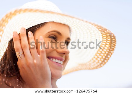 happy young woman with summer hat daydreaming