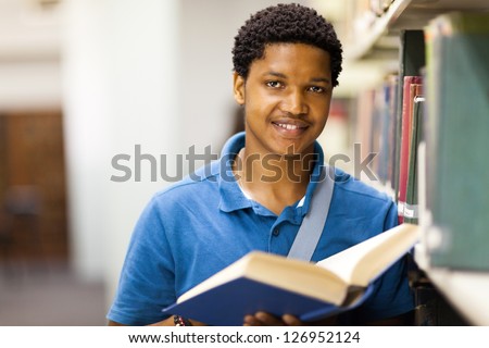 male african american college student reading book in library