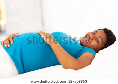 pregnant african american woman lying on bed