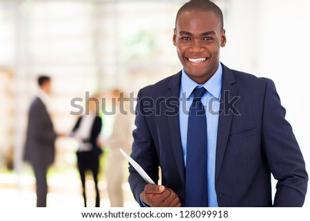 handsome african american businessman with tablet computer in office