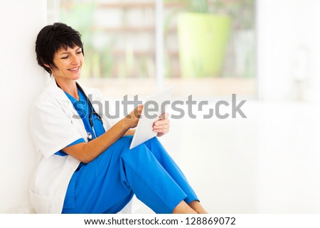 pretty female middle aged hospital worker using tablet computer